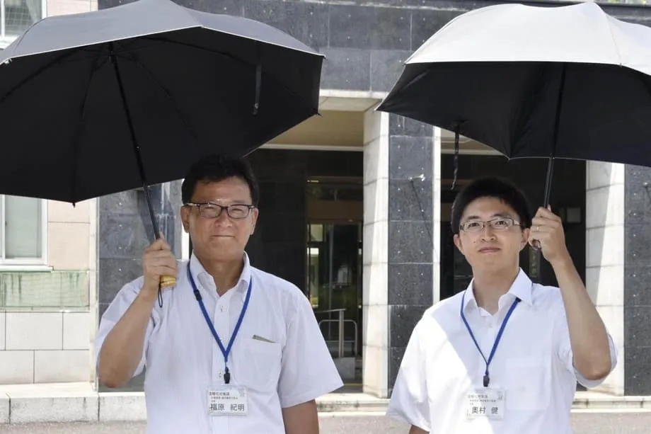 No calor escaldante do Japão, homens recorrem a guarda-sóis para se refrescar